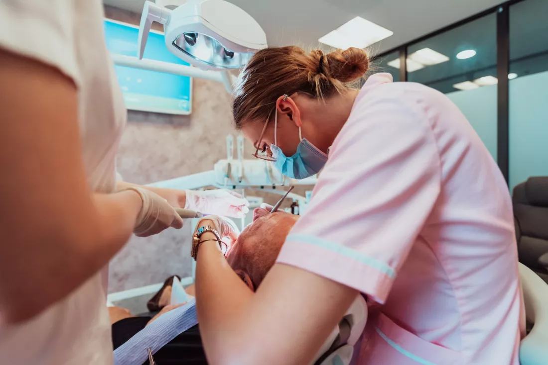 Asystentka stomatologiczna pomaga dentyscie podczas zabiegu