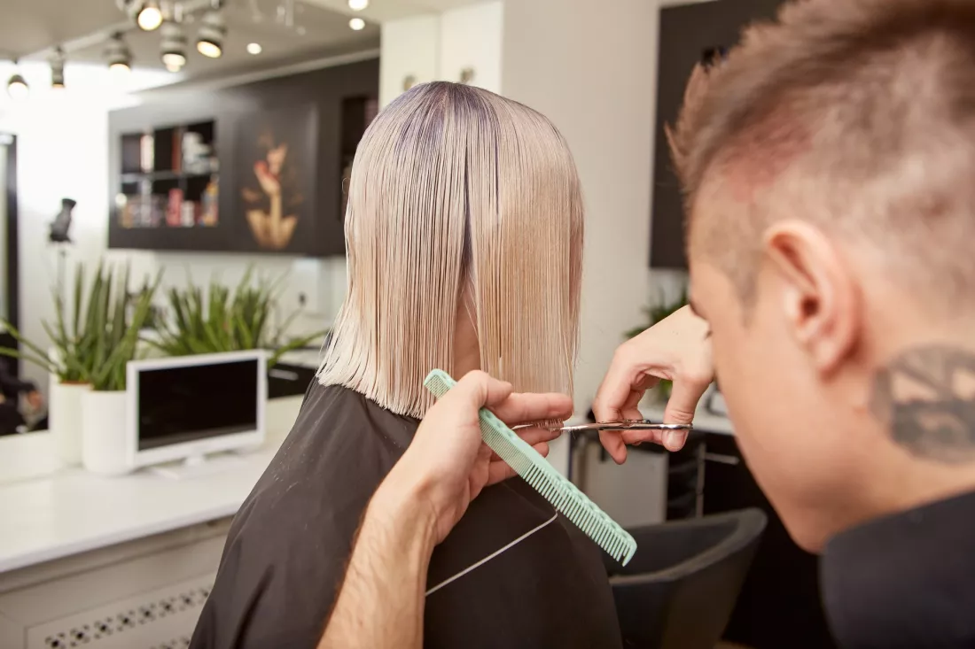 Fryzjerka strzyze klientke w salonie fryzjerskim